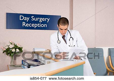 Stock Photo - Doctor looking at paperwork. Fotosearch