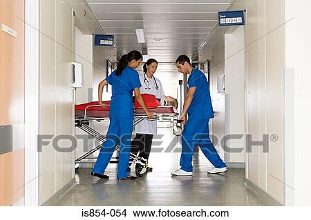 Doctors with patient on hospital trolley View Large Photo Image Picture - Doctors with patient on hospital trolley. Fotosearch