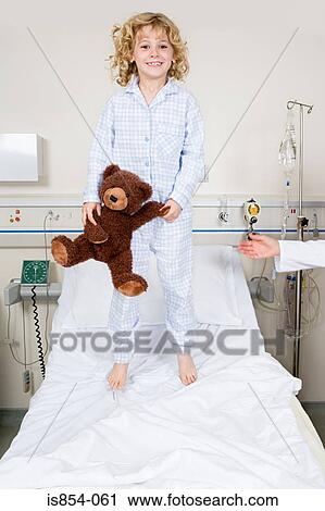 Stock Image - Girl jumping on hospital bed. Fotosearch