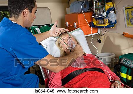 Stock Photo - Nurse putting oxygen mask on patient. Fotosearch