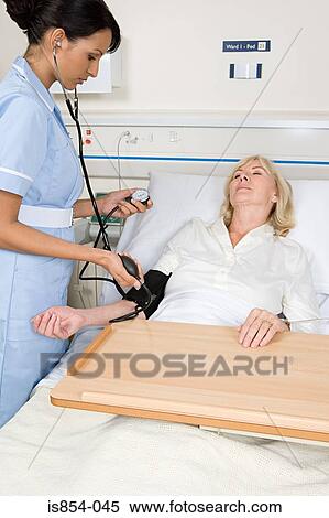 Stock Photography - Nurse taking patients blood pressure. Fotosearch