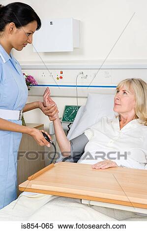 Stock Photography - Nurse taking patients blood pressure. Fotosearch
