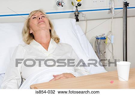 Woman asleep in hospital bed with tablets View Large Photo Image Stock Image - Woman asleep in hospital bed with tablets. Fotosearch