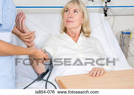 Woman having her blood pressure taken View Large Photo Image Stock Photograph - Woman having her blood pressure taken. Fotosearch