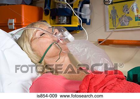Stock Photo - Woman wearing oxygen mask. Fotosearch