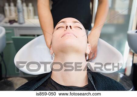 Stock Image - A woman having hair washed. Fotosearch