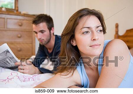 Couple relaxing in bed View Large Photo Image Stock Photo - Couple relaxing in bed. Fotosearch