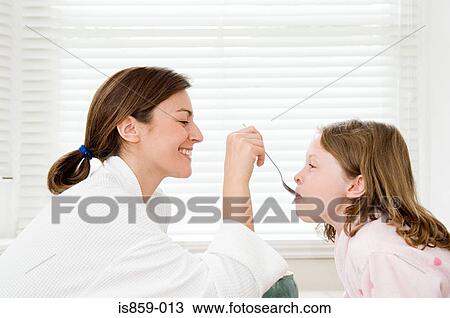 Mother feeding her daughter View Large Photo Image Stock Image - Mother feeding her daughter. Fotosearch