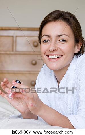 Woman holding a bottle of nail polish View Large Photo Image Stock Photo - Woman holding a bottle of nail polish. Fotosearch