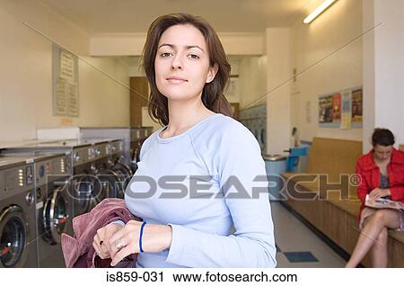 Stock Image - Woman in a laundrette. Fotosearch
