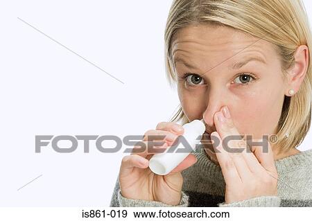 Woman inhaling nasal spray View Large Photo Image Stock Photo - Woman inhaling nasal spray. Fotosearch