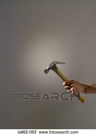 Stock Image - Person holding a hammer. Fotosearch