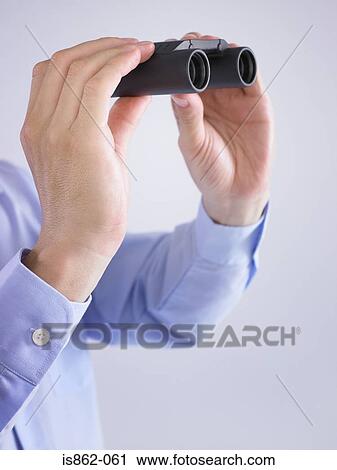 Stock Image - Person holding binoculars. Fotosearch