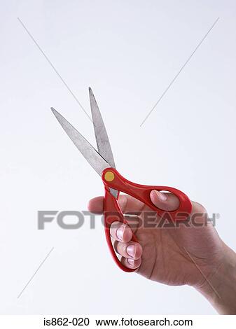Stock Image - Person holding scissors. Fotosearch