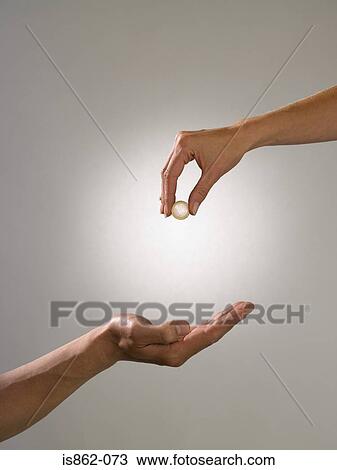 Woman holding coin above mans hand View Large Photo Image Stock Image - Woman holding coin above mans hand. Fotosearch