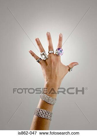 Stock Photo - Woman wearing rings and bracelets. Fotosearch