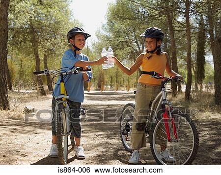 Boy and girl on bikes with water bottles View Large Photo Image Stock Photograph - Boy and girl on bikes with water bottles. Fotosearch