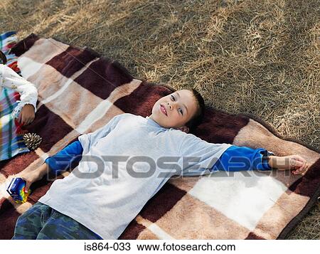 Boy lying on blanket View Large Photo Image Stock Image - Boy lying on blanket. Fotosearch