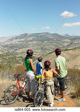 Stock Image - Family with bicycles looking at view. Fotosearch