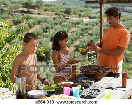 Stock Photo - Father serving food to children. Fotosearch