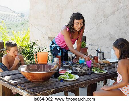 Mother serving meal to children View Large Photo Image Stock Image - Mother serving meal to children. Fotosearch