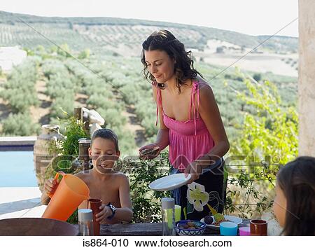 Woman and children having meal outdoors View Large Photo Image Stock Image - Woman and children having meal outdoors. Fotosearch
