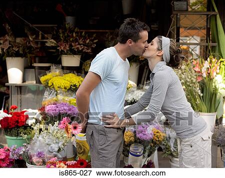 Couple kissing by flower stall View Large Photo Image Stock Photo - Couple kissing by flower stall. Fotosearch