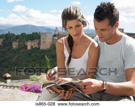 Couple looking at guidebook View Large Photo Image Stock Photo - Couple looking at guidebook. Fotosearch