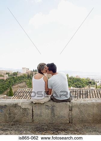 Couple on kissing on wall View Large Photo Image Stock Image - Couple on kissing on wall. Fotosearch