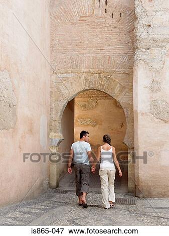 Couple walking near old building View Large Photo Image Stock Photo - Couple walking near old building. Fotosearch