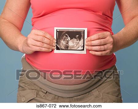 A pregnant woman holding scan View Large Photo Image Stock Image - A pregnant woman holding scan. Fotosearch
