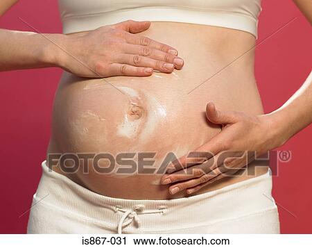 Pregnant woman applying moisturiser View Large Photo Image Stock Image - Pregnant woman applying moisturiser. Fotosearch