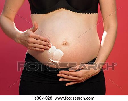 Pregnant woman applying moisturiser View Large Photo Image Stock Photo - Pregnant woman applying moisturiser. Fotosearch