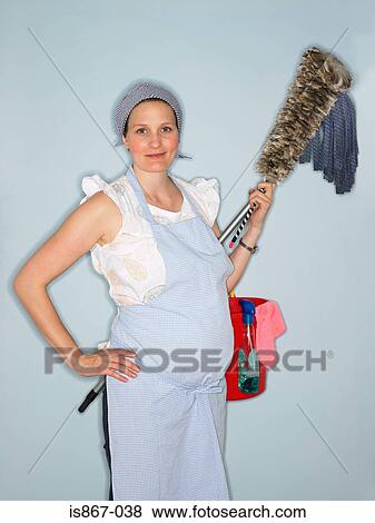 Pregnant woman carrying cleaning equipment View Large Photo Image Stock Photo - Pregnant woman carrying cleaning equipment. Fotosearch