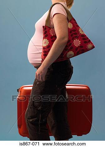 Pregnant woman carrying suitcase View Large Photo Image Stock Image - Pregnant woman carrying suitcase. Fotosearch
