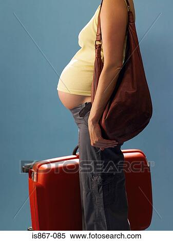 Pregnant woman carrying suitcase View Large Photo Image Stock Photography - Pregnant woman carrying suitcase. Fotosearch