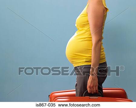 Pregnant woman carrying suitcases View Large Photo Image Stock Photography - Pregnant woman carrying suitcases. Fotosearch