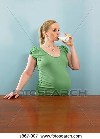 Pregnant woman drinking milk View Large Photo Image Stock Photo - Pregnant woman drinking milk. Fotosearch