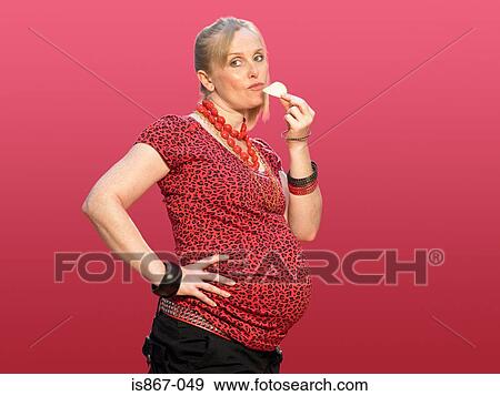 Pregnant woman eating a crisp View Large Photo Image Stock Photo - Pregnant woman eating a crisp. Fotosearch