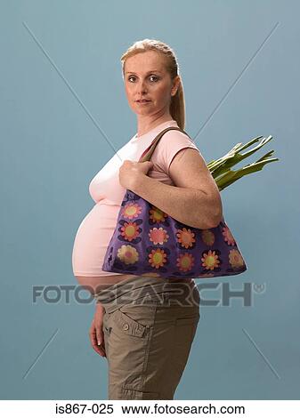 Pregnant woman holding bag View Large Photo Image Stock Photography - Pregnant woman holding bag. Fotosearch
