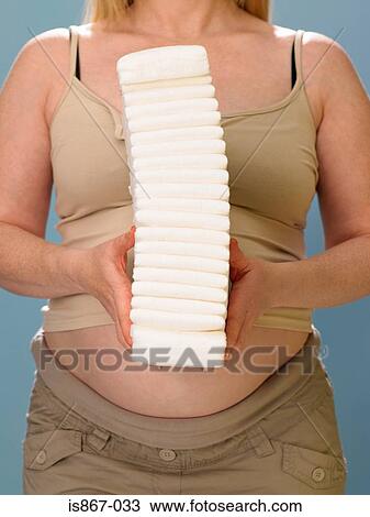 Pregnant woman holding pile of nappies View Large Photo Image Stock Image - Pregnant woman holding pile of nappies. Fotosearch