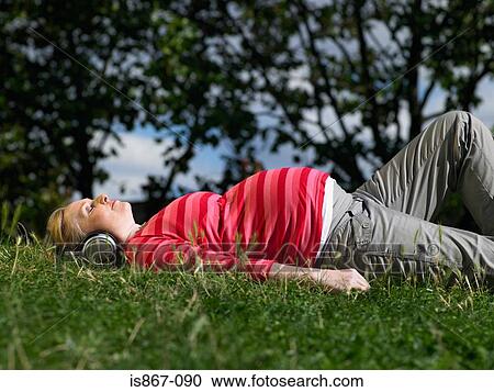 Stock Image - Pregnant woman listening to music. Fotosearch