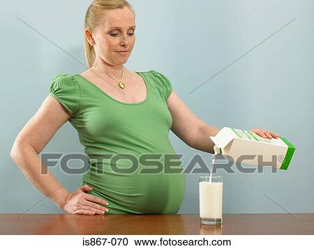 Pregnant woman pouring milk View Large Photo Image Stock Image - Pregnant woman pouring milk. Fotosearch