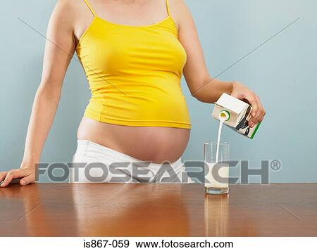 Pregnant woman pouring milk View Large Photo Image Stock Photo - Pregnant woman pouring milk. Fotosearch