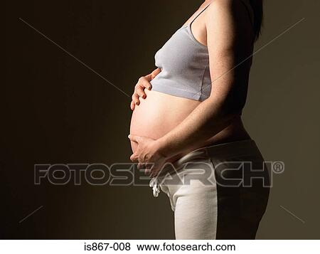 Stock Photo - Pregnant woman touching stomach. Fotosearch