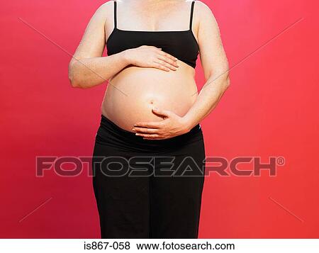 Pregnant woman touching stomach View Large Photo Image Stock Photo - Pregnant woman touching stomach. Fotosearch