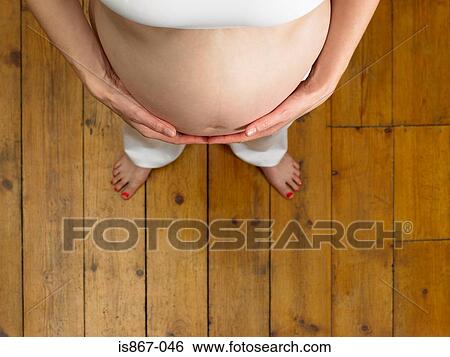 Pregnant woman touching stomach View Large Photo Image Stock Photograph - Pregnant woman touching stomach. Fotosearch