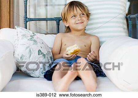 Boy eating a breadroll View Large Photo Image Stock Image - Boy eating a breadroll. Fotosearch