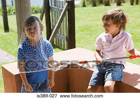 Boys playing with a fishing net View Large Photo Image Stock Photo - Boys playing with a fishing net. Fotosearch