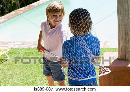Boys playing with a fishing net View Large Photo Image Stock Photo - Boys playing with a fishing net. Fotosearch